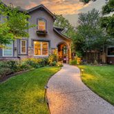 a front view of a house with a yard and garden