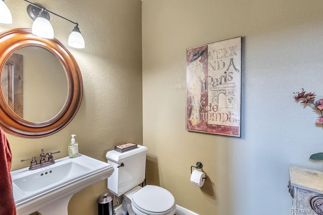 a bathroom with a toilet a sink and a mirror
