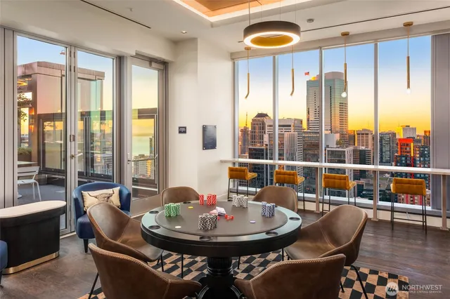 a dining room with furniture and large windows