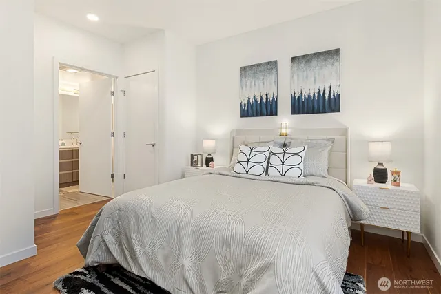 a spacious bedroom with a bed and wooden floor