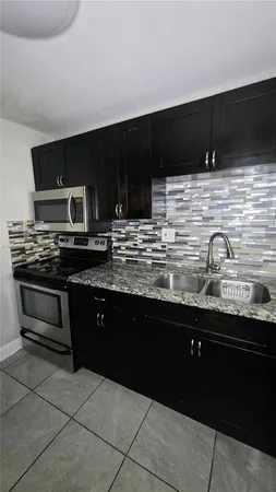 a kitchen with stainless steel appliances a sink stove and microwave