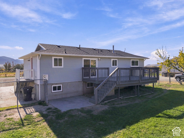 224 Canal Bank Road Garland, UT 84312 - Photo 7 of 21 Rear exterior with an elevated wood-finish deck, concrete patio, and light-colored siding