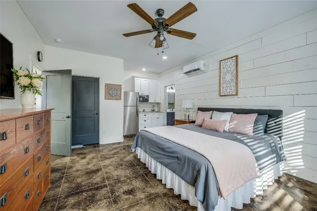 a spacious bedroom with a bed and a flat screen tv