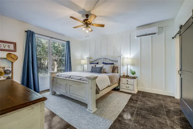 a bedroom with a large bed a flat screen tv and a chandelier