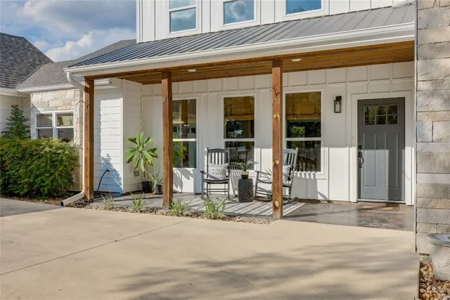a view of a balcony with chairs and a potted plant on a wall