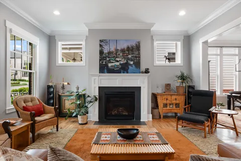 a living room with furniture a rug a window and a fireplace
