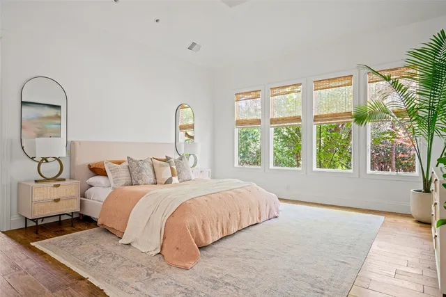 a bedroom with a bed and a large window with outer view
