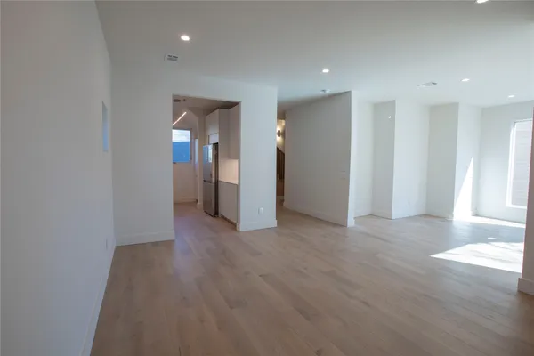 a view of a hallway with wooden floor and a living room