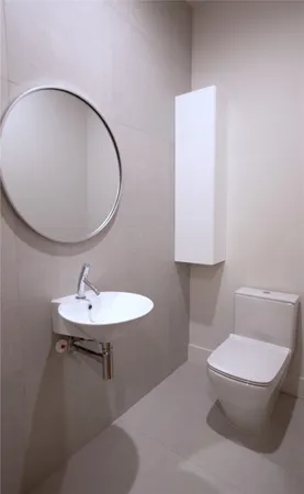 a bathroom with a toilet a sink and mirror