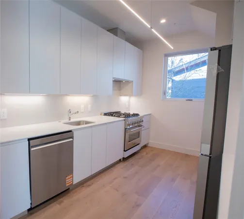 a kitchen with granite countertop a sink cabinets and stainless steel appliances