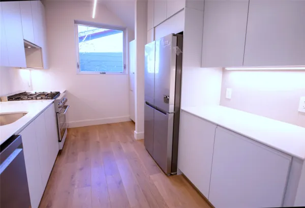a kitchen with a wooden floor and a stove top oven