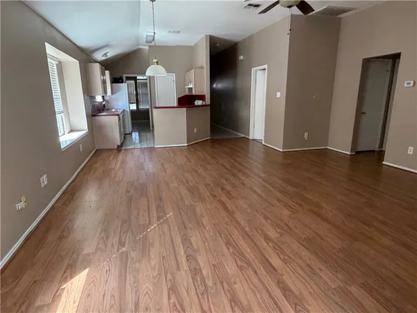 a view of a kitchen counter space with wooden floor and windows