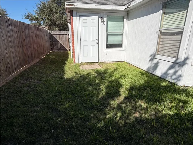 a view of backyard with small cabin and wooden fence