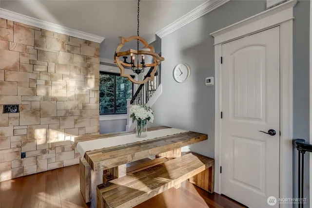 a dining room with wooden floor table and chairs