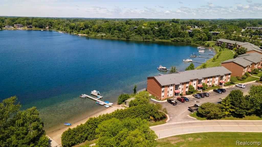 1974 Klingensmith Road, Unit 4 Bloomfield Hills, MI 48302 - Photo 3 of 35 Waterfront property featuring multiple residential buildings with brick exteriors, private docks, and a sandy shoreline
