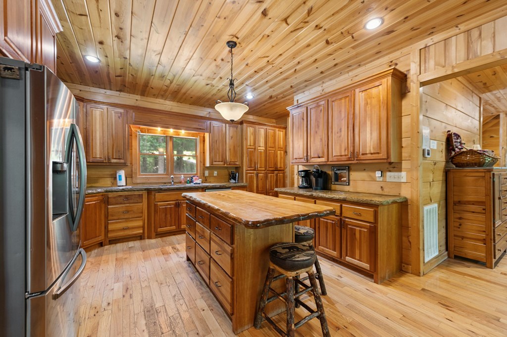 1082 Sunset Road Epworth, GA 30541 - Photo 42 of 69 a kitchen with stainless steel appliances granite countertop a stove a refrigerator a sink dishwasher and wooden cabinets with wooden floor
