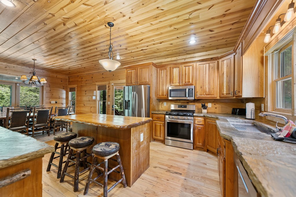 1082 Sunset Road Epworth, GA 30541 - Photo 45 of 69 a kitchen with stainless steel appliances granite countertop a stove top oven a sink dishwasher a dining table and chairs with wooden floor