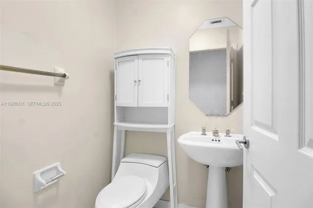 a bathroom with a toilet sink and mirror