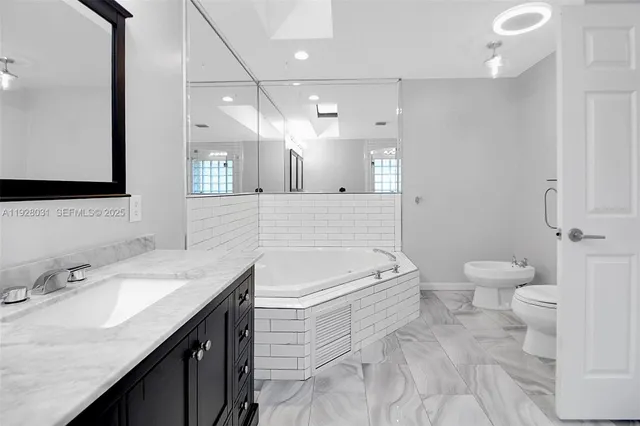 a bathroom with a sink a toilet and a mirror