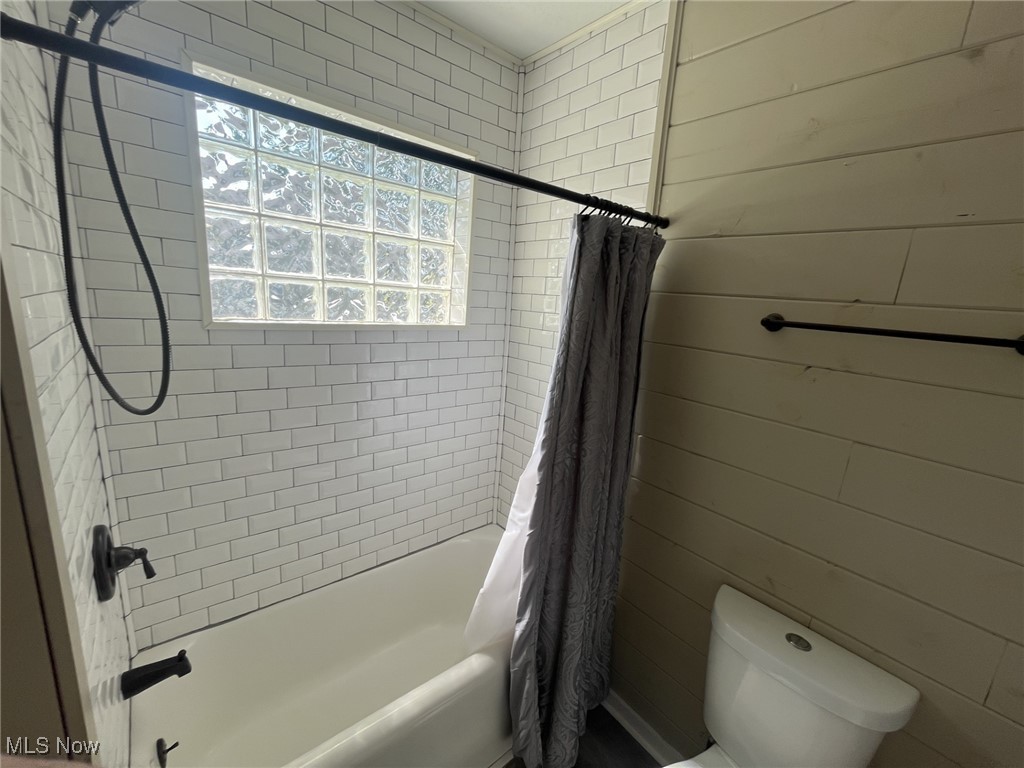 4440 Dryden Court Southwest Canton, OH 44708 - Photo 18 of 28 Bathroom featuring shower / bath combo and wooden walls