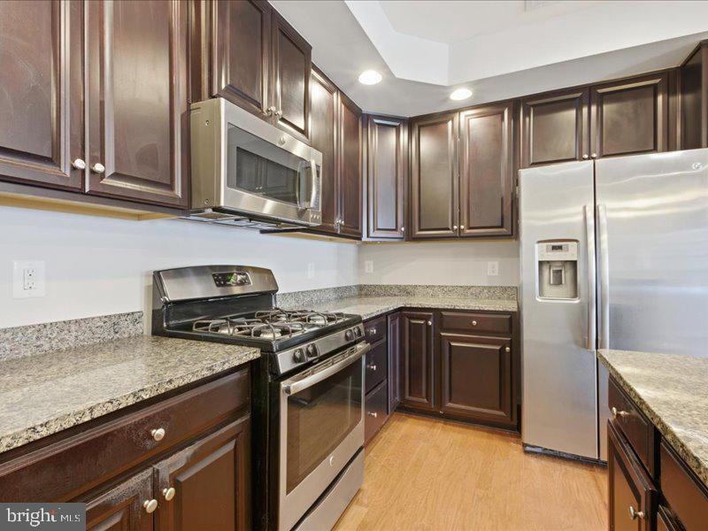 42143 Piebald Square Aldie, VA 20105 - Photo 11 of 34 a kitchen with stainless steel appliances granite countertop a stove a refrigerator and a sink