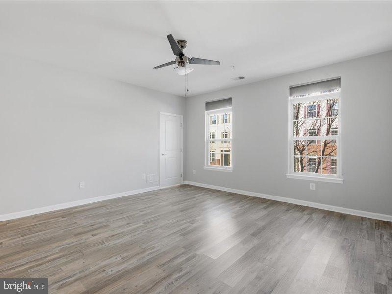 42143 Piebald Square Aldie, VA 20105 - Photo 19 of 34 a view of an empty room with wooden floor and a window