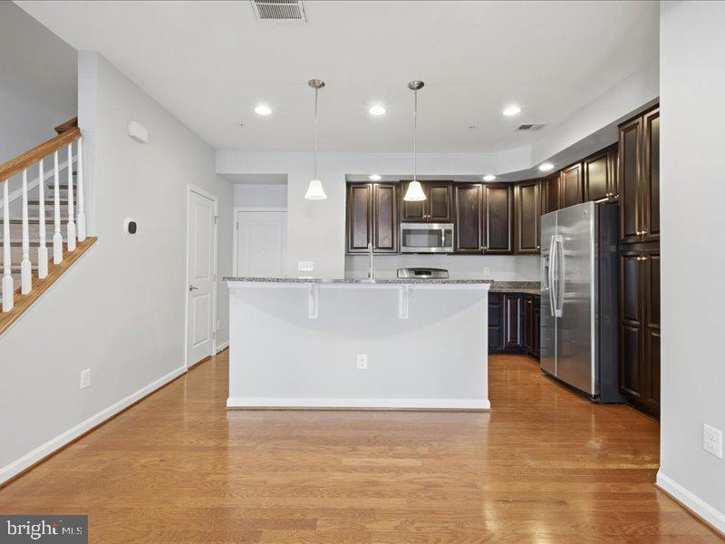 42143 Piebald Square Aldie, VA 20105 - Photo 5 of 34 a large kitchen with stainless steel appliances a refrigerator a stove top oven and a sink