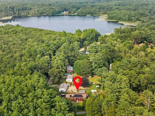 an aerial view of a house with a yard and lake view