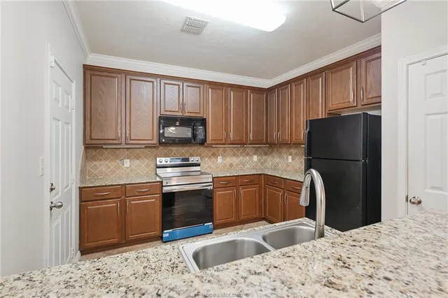 a kitchen with a refrigerator sink and wooden cabinets