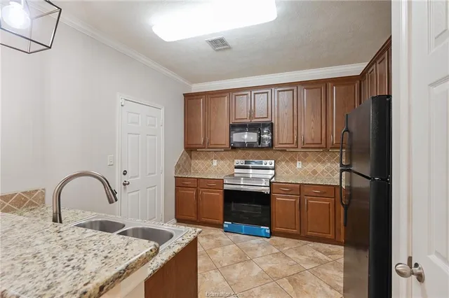 a kitchen with stainless steel appliances granite countertop a sink stove and refrigerator