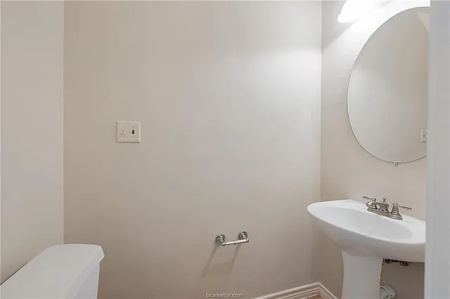 a bathroom with a sink mirror and toilet