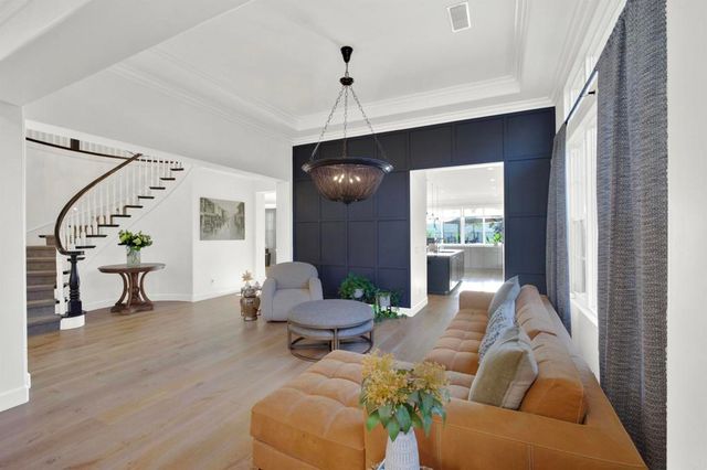 a living room with furniture a fireplace and a chandelier