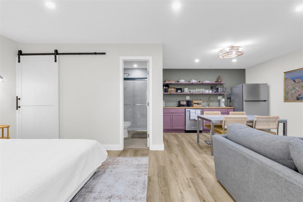 4121 Junius Street, Unit B Dallas, TX 75246 - Photo 12 of 32 Open-concept living space featuring wood-finish flooring, recessed lighting, and a modern kitchen area with purple cabinetry