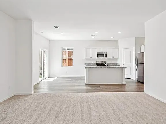 a kitchen with stainless steel appliances a refrigerator sink and microwave