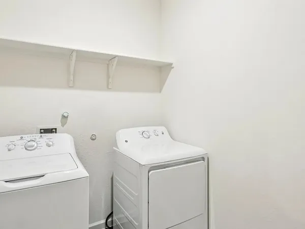 a view of kitchen with granite countertop cabinets and refrigerator