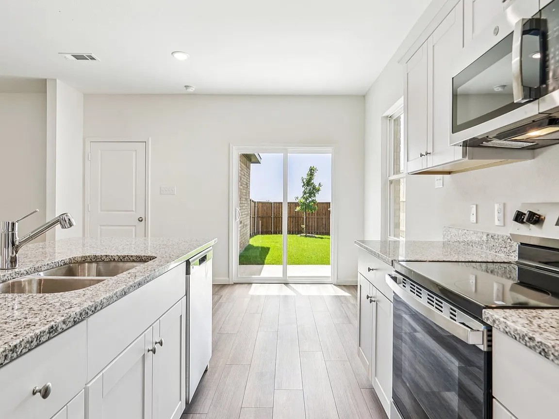 152 Mullen Way Taylor, TX 76574 - Photo 5 of 21 a kitchen with a sink stove and cabinets