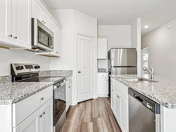 152 Mullen Way Taylor, TX 76574 - Photo 6 of 21 a kitchen with stainless steel appliances granite countertop a refrigerator stove and sink