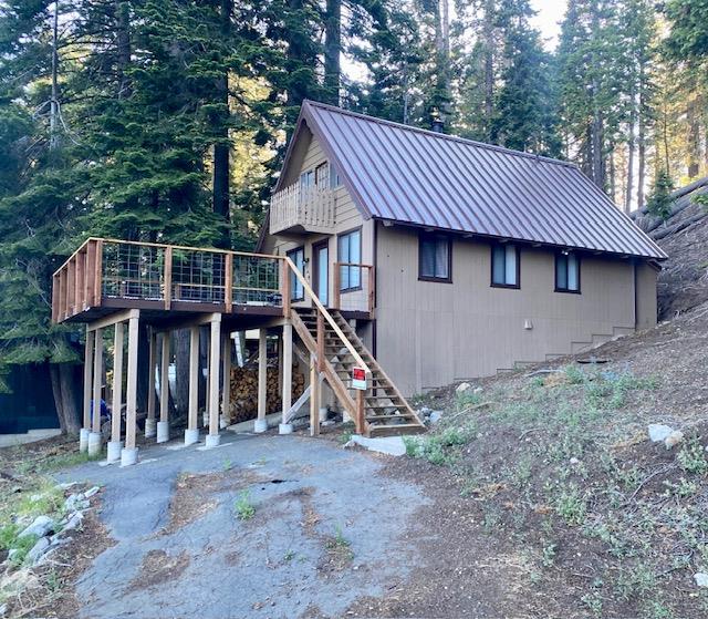 a view of a house with a yard and wooden deck
