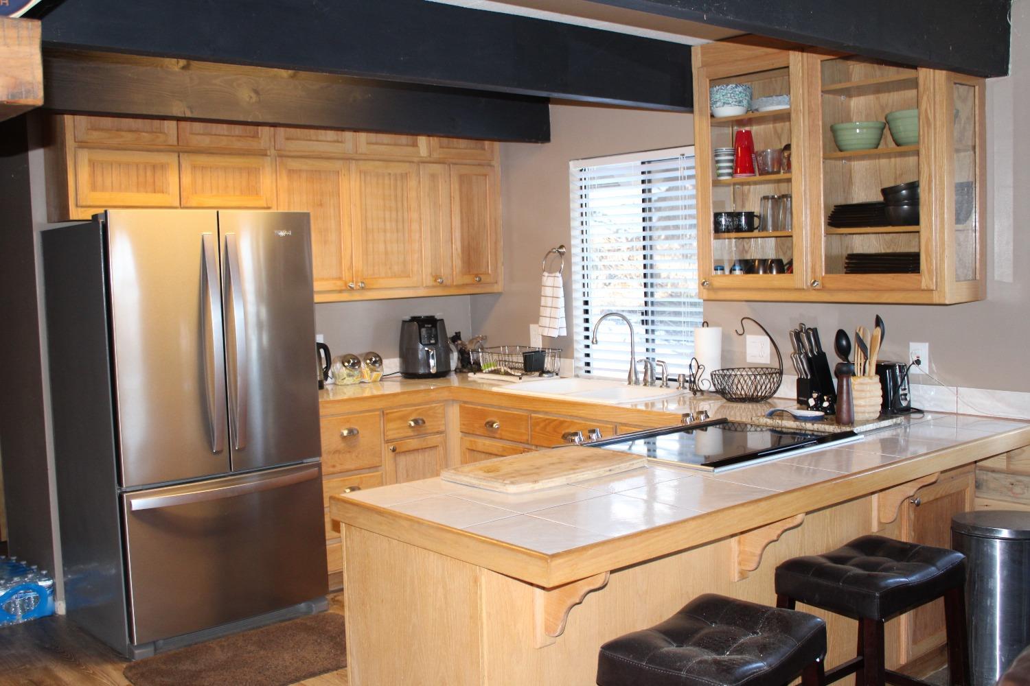 1140 Mountain View Road Arnold, CA 95223 - Photo 9 of 24 a kitchen with a refrigerator a sink and cabinets