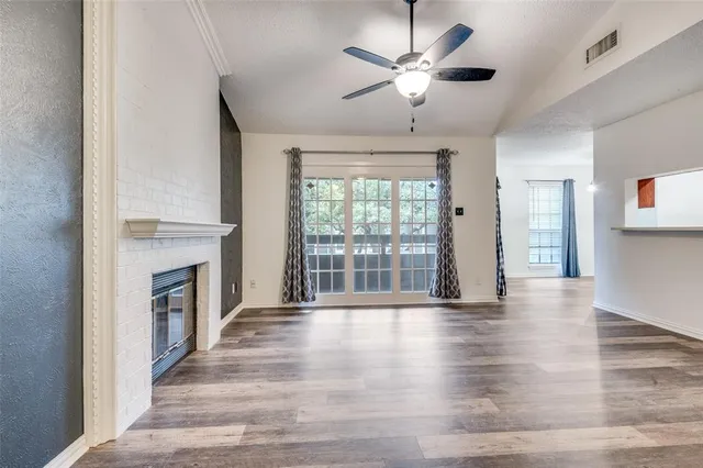 a view of an empty room with a fireplace and a window