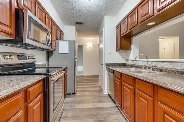 a kitchen with stainless steel appliances granite countertop a sink and a stove