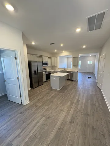 a view of kitchen with refrigerator stove and wooden floor