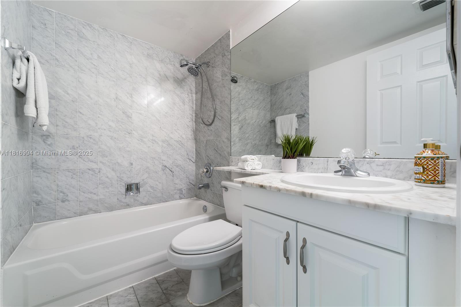 800 Claughton Island Drive, Unit 1103 Miami, FL 33131 - Photo 23 of 40 a bathroom with a granite countertop sink a toilet and bathtub