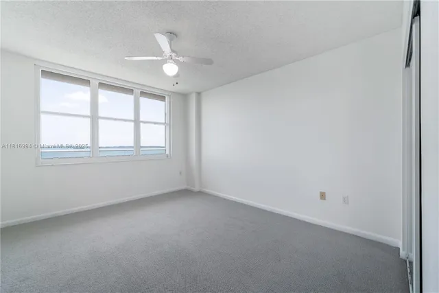 an empty room with a ceiling fan and a bathroom
