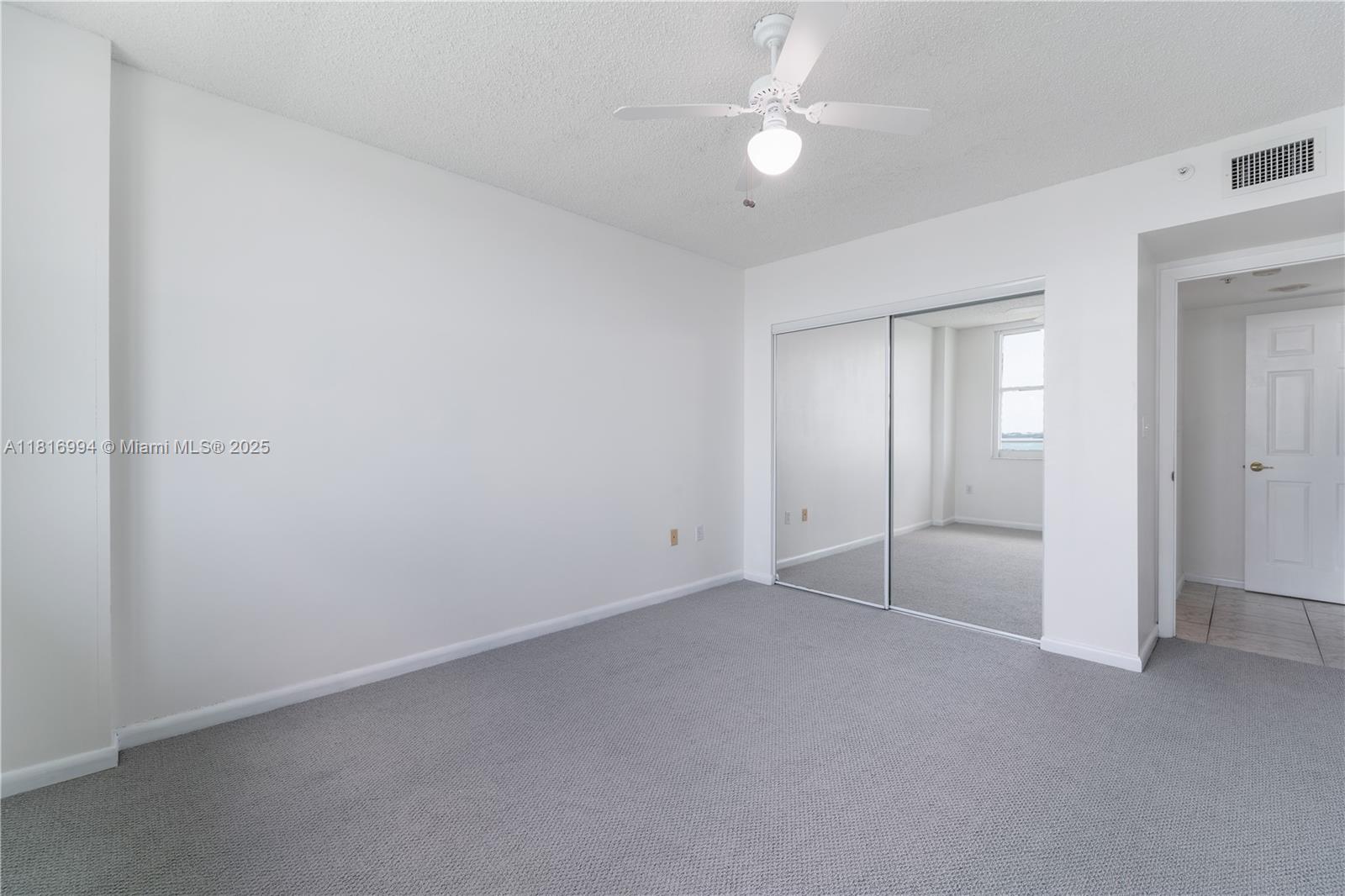 800 Claughton Island Drive, Unit 1103 Miami, FL 33131 - Photo 30 of 40 an empty room with a ceiling fan and a bathroom
