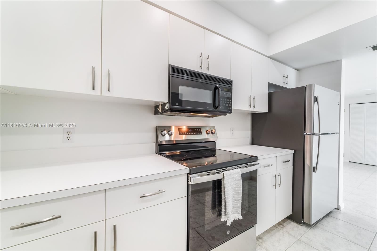 800 Claughton Island Drive, Unit 1103 Miami, FL 33131 - Photo 40 of 40 a kitchen with granite countertop a refrigerator stove and microwave
