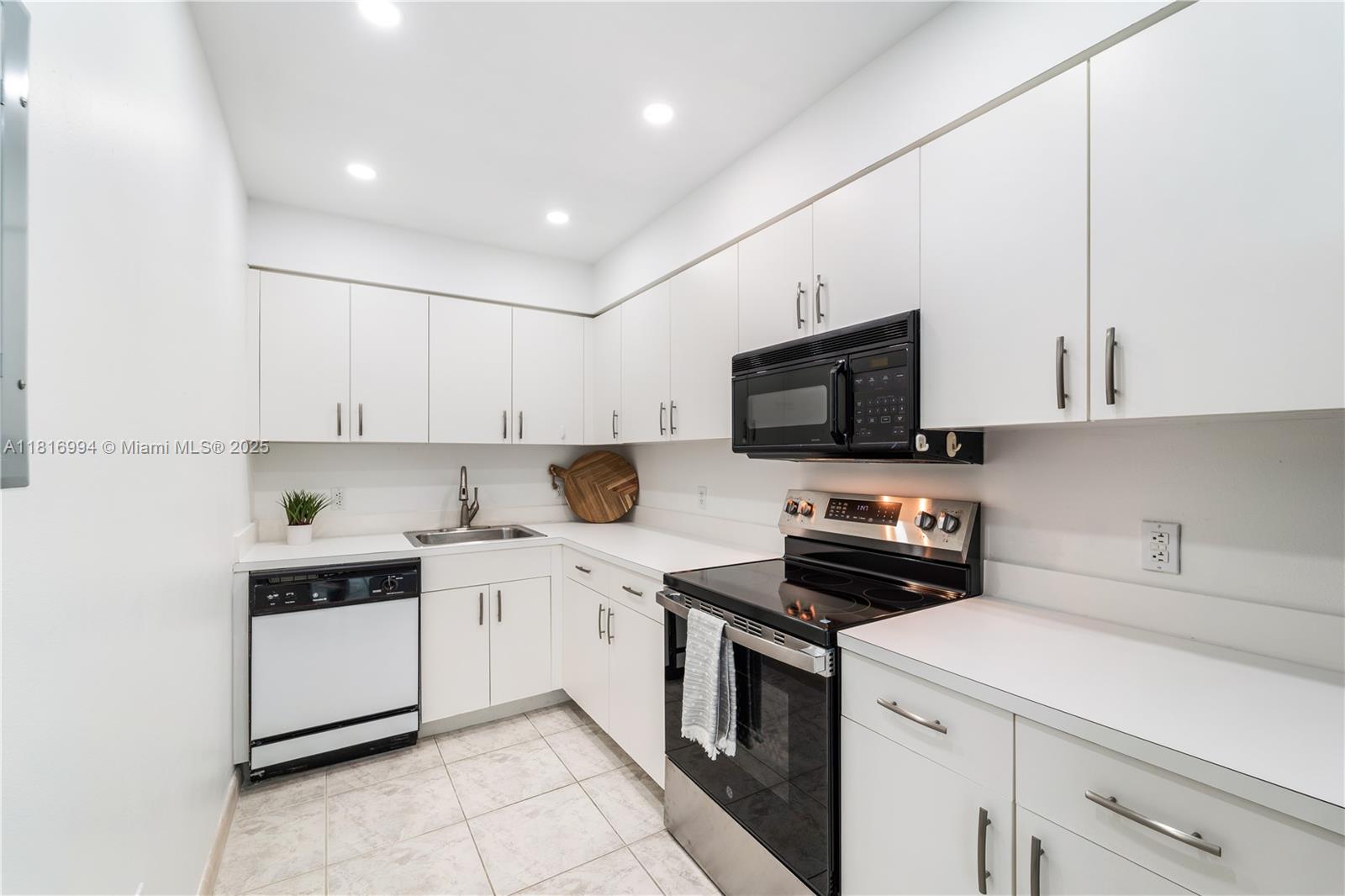 800 Claughton Island Drive, Unit 1103 Miami, FL 33131 - Photo 5 of 40 a kitchen with a sink a stove and cabinets