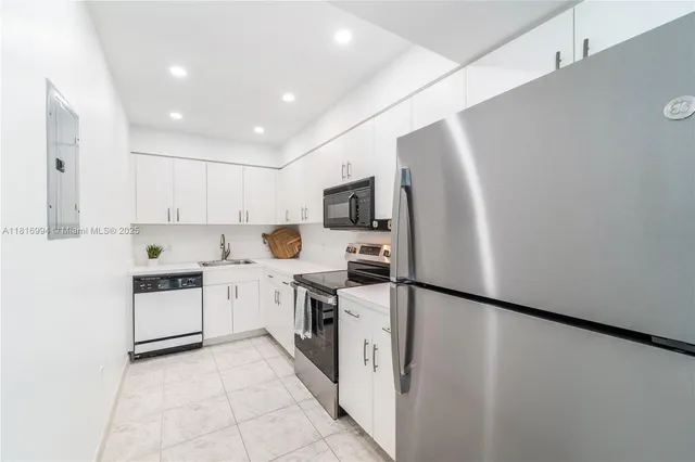 a kitchen with stainless steel appliances granite countertop a refrigerator a stove top oven a sink and dishwasher