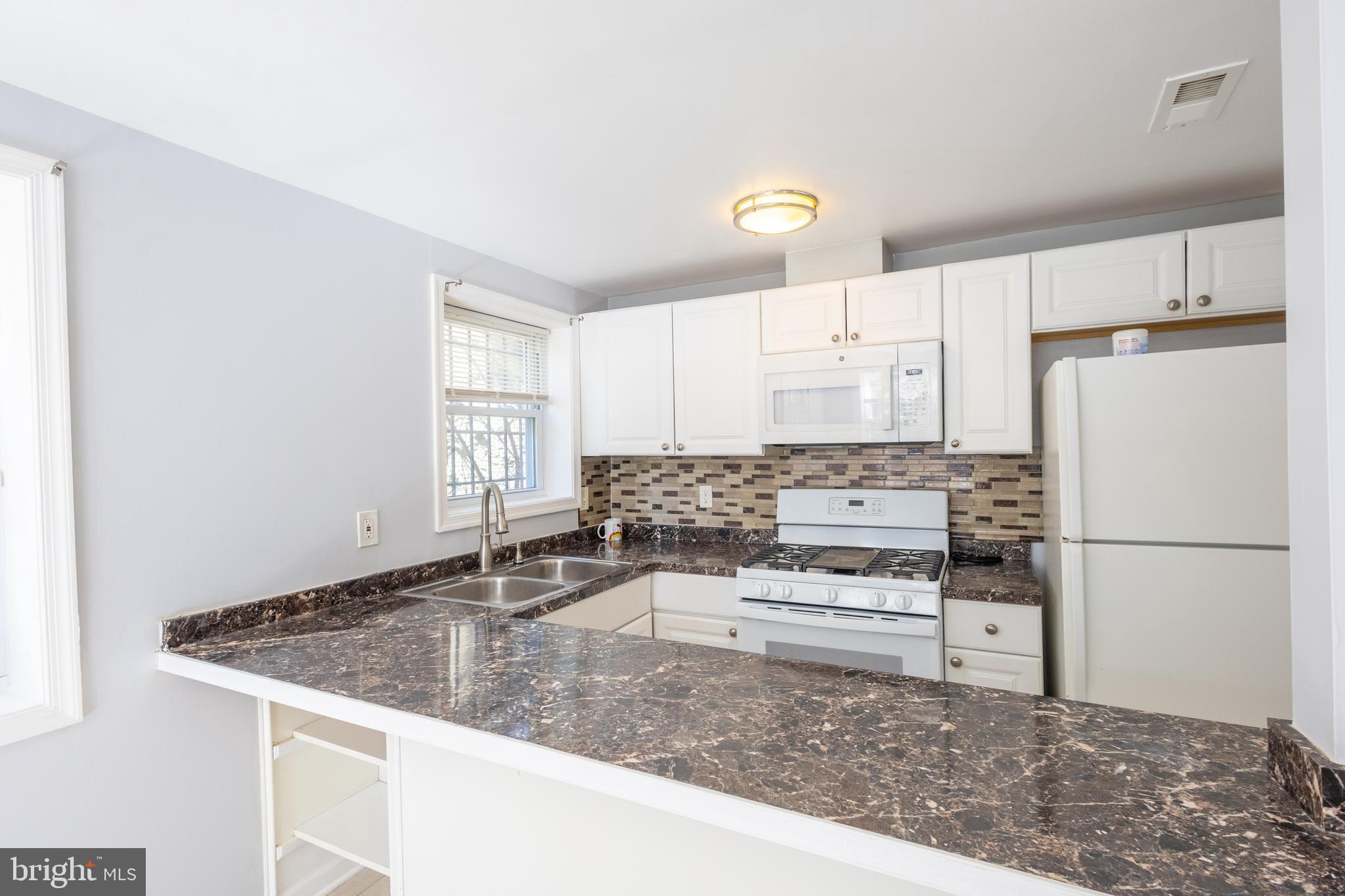 314 Atlantic Street Southeast, Unit 1 Washington, DC 20032 - Photo 14 of 17 a kitchen with a refrigerator a stove a sink and white cabinets