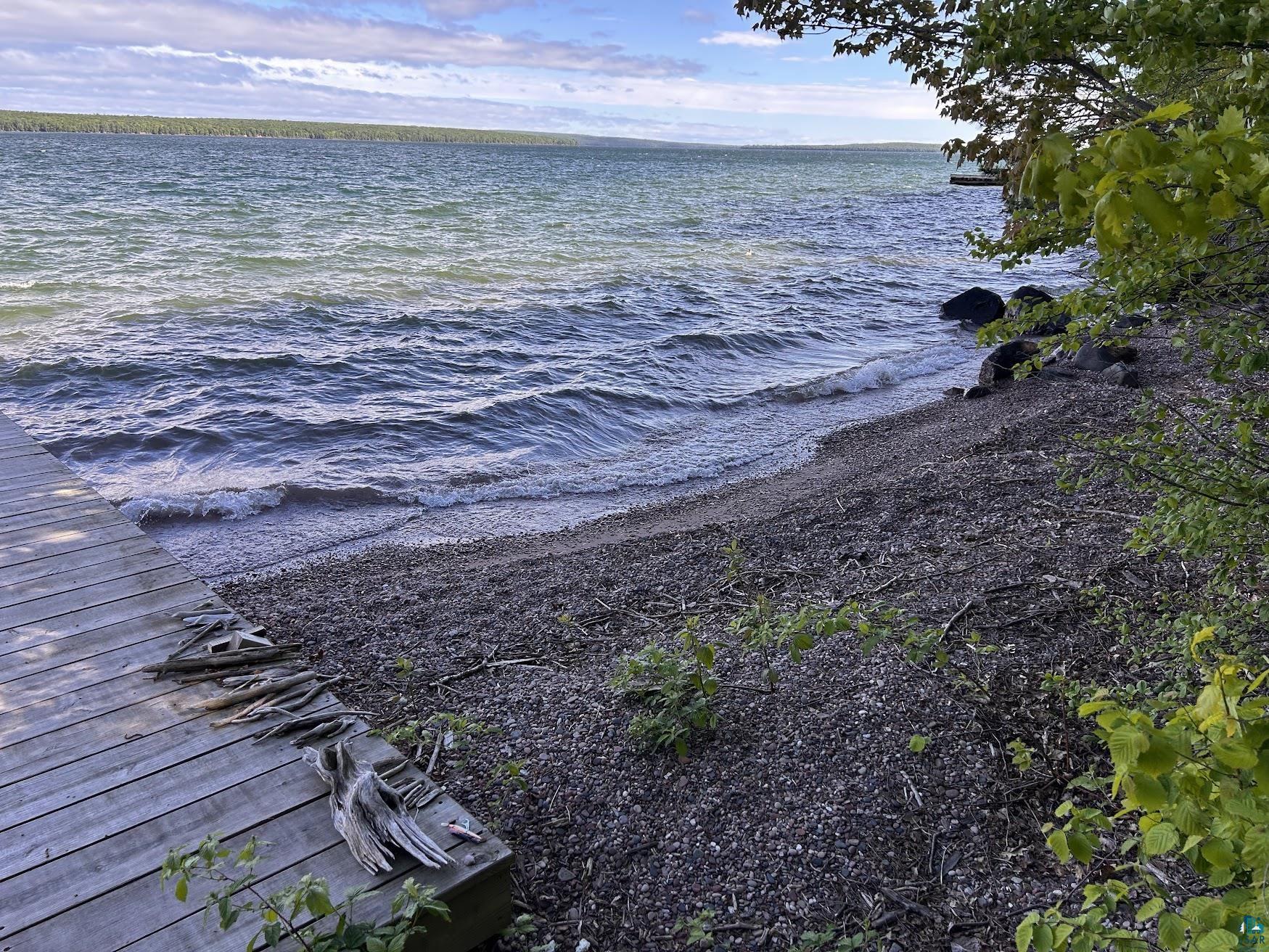 1596 North Shore Road La Pointe, WI 54850 - Photo 18 of 21 Waterfront property featuring a wood dock, a pebbled beach, and a shoreline with mature trees